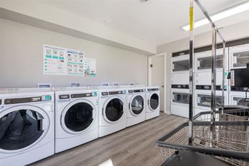 Laundry room with washers and dryers and a cart